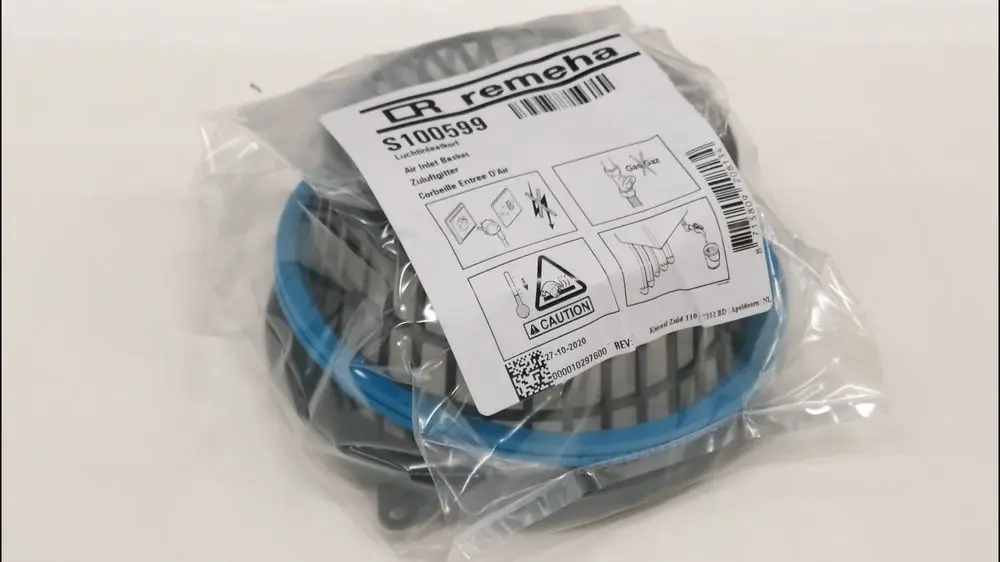 Remeha Zuluftgitter in einer durchsichtigen Verpackung mit blauer Umrandung und Montageanweisungen. Verpackung zeigt Warnhinweise und Verwendungshinweise.
